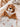 Doudou lion plat personnalisable en minky camel, posé dans un berceau pour bébé