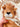Doudou lion plat personnalisable en minky camel, tenu dans une main au dessus d'un berceau pour bébé